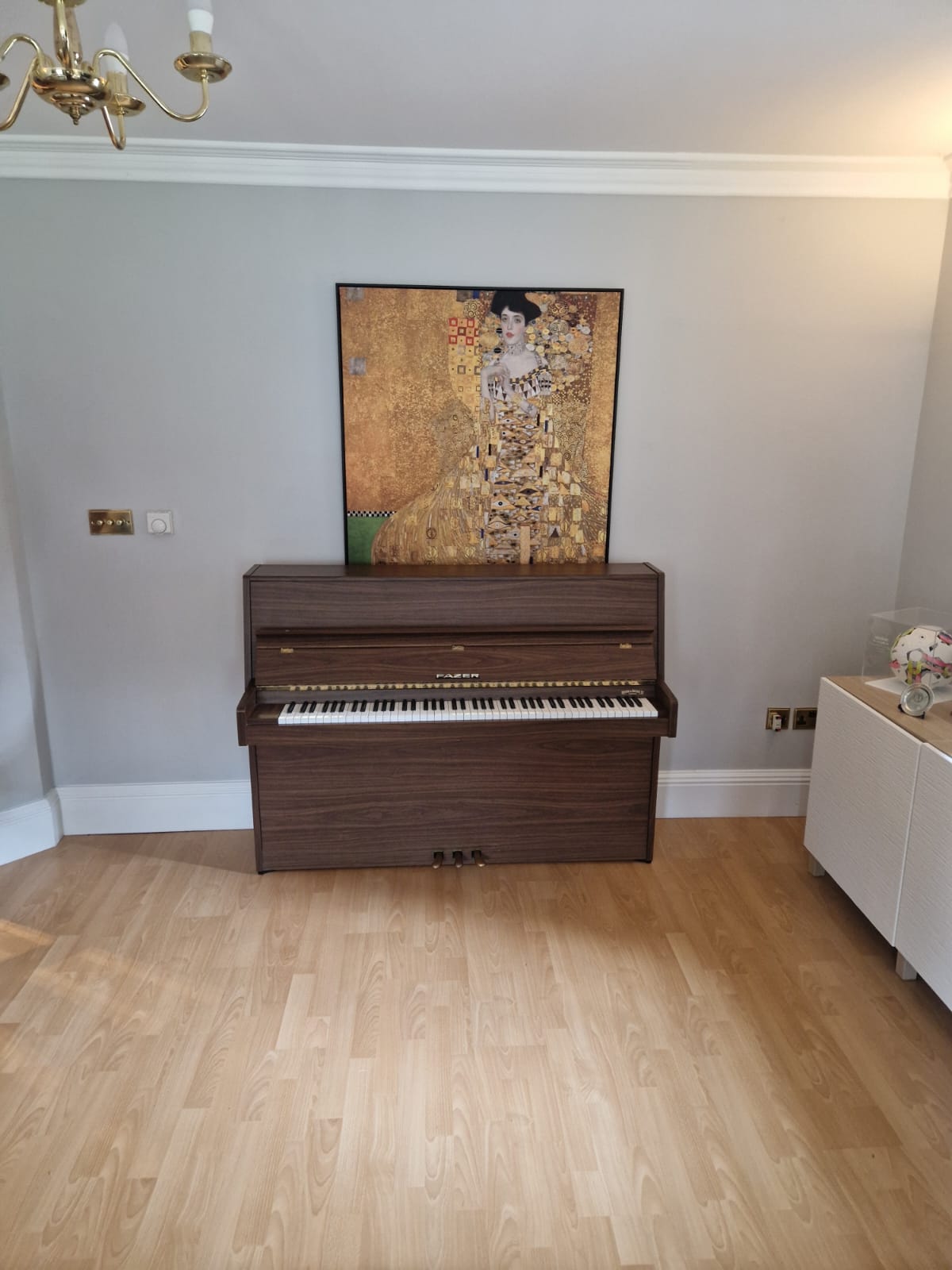 Piano in a room with a painting in the back